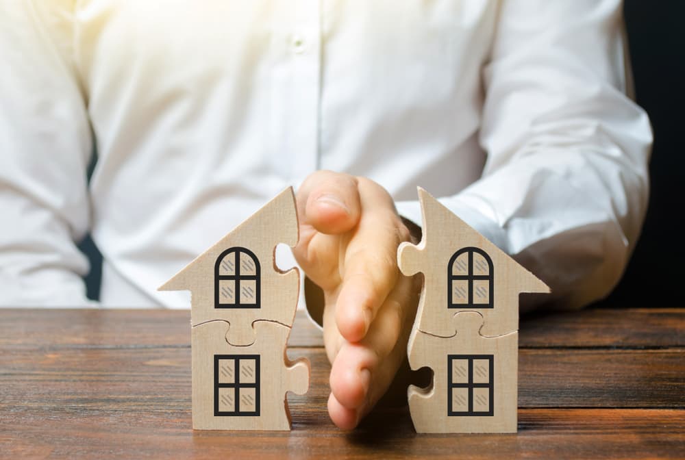 A lawyer divides a house or property between owners, representing the division process of real estate between former spouses or relatives due to divorce or other legal reasons.