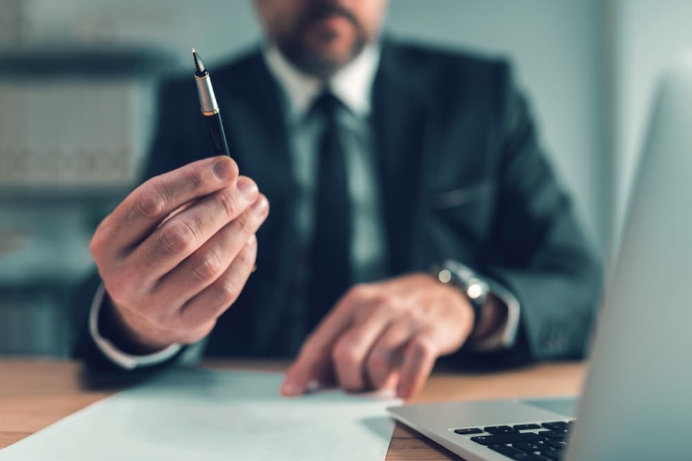 Insurance officer providing pen for client to sign agreement document, selective focus