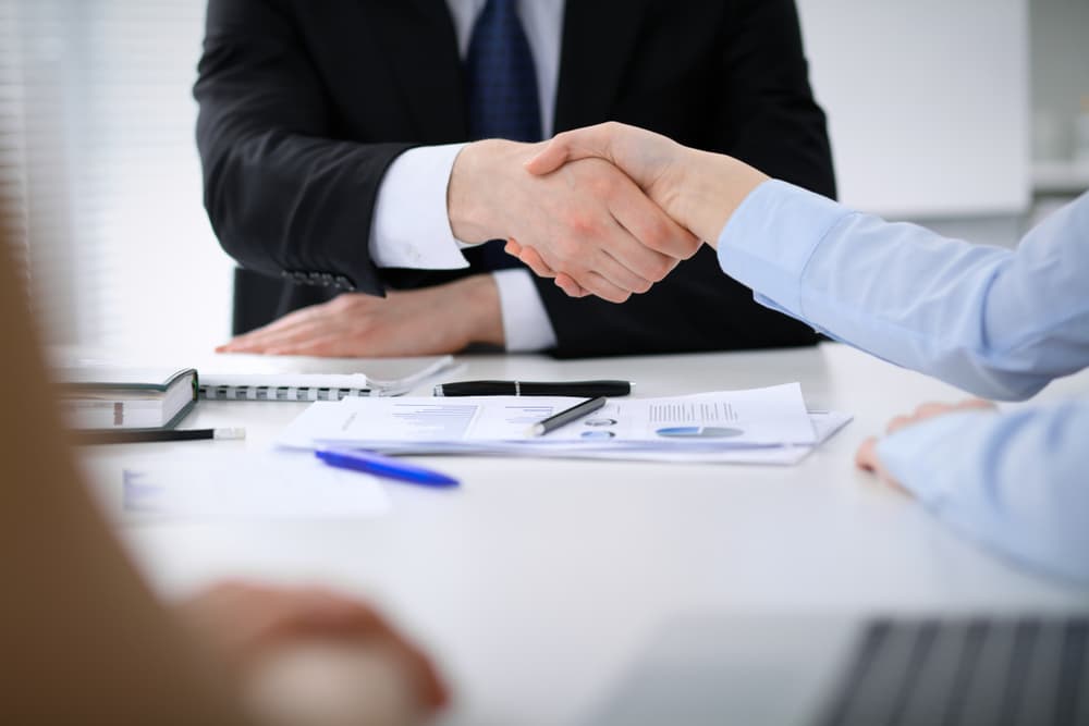 Close-up of unidentified business people shaking hands after concluding a meeting. Concept of agreement, success, and communication.