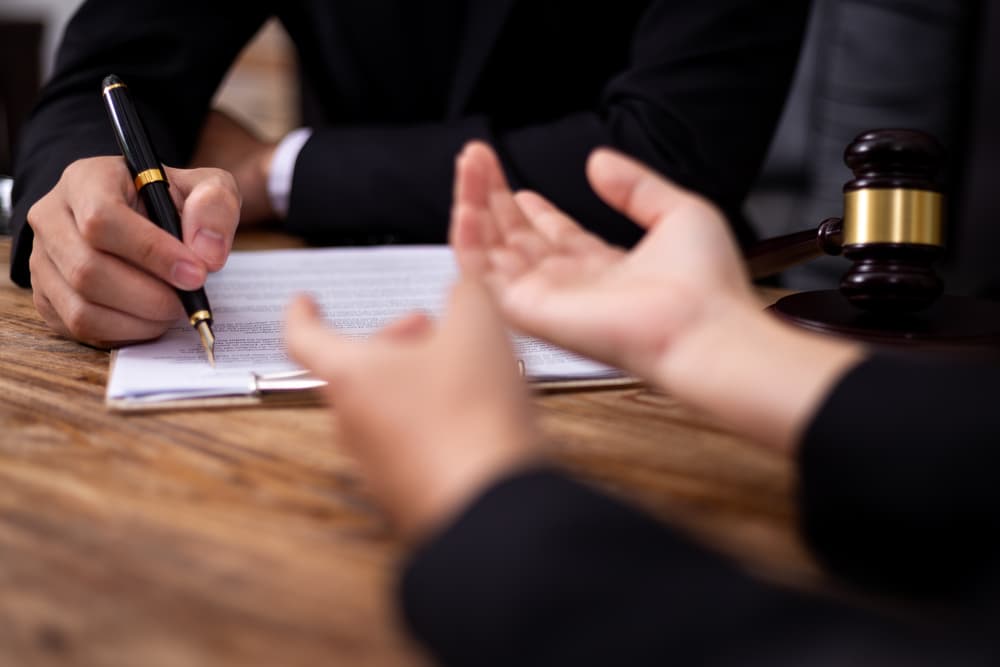 Businessman consulting with a lawyer or judge for mediation, discussing legal services and government assistance.