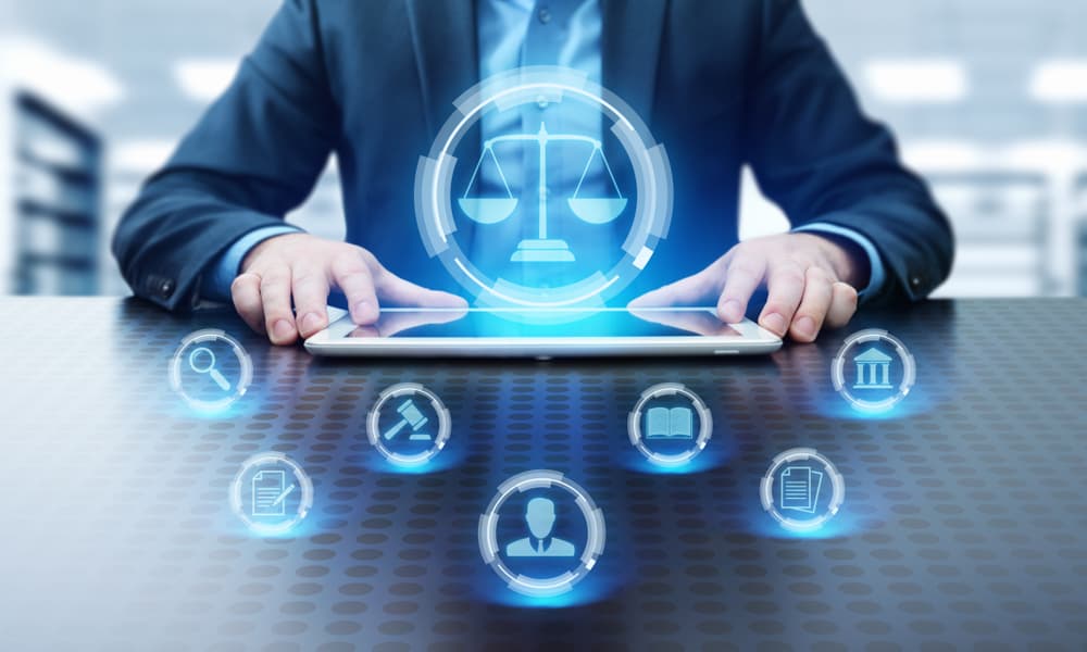 A person using a tablet with digital icons representing various legal services and scales of justice.