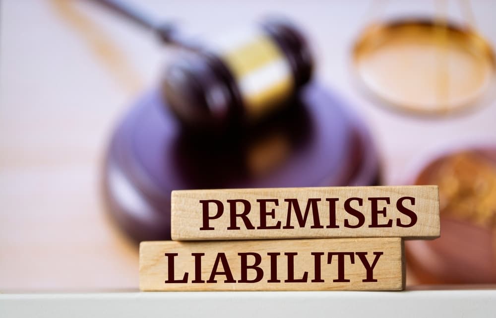 Wooden blocks reading "Premises Liability" in front of a judge's gavel and scales.