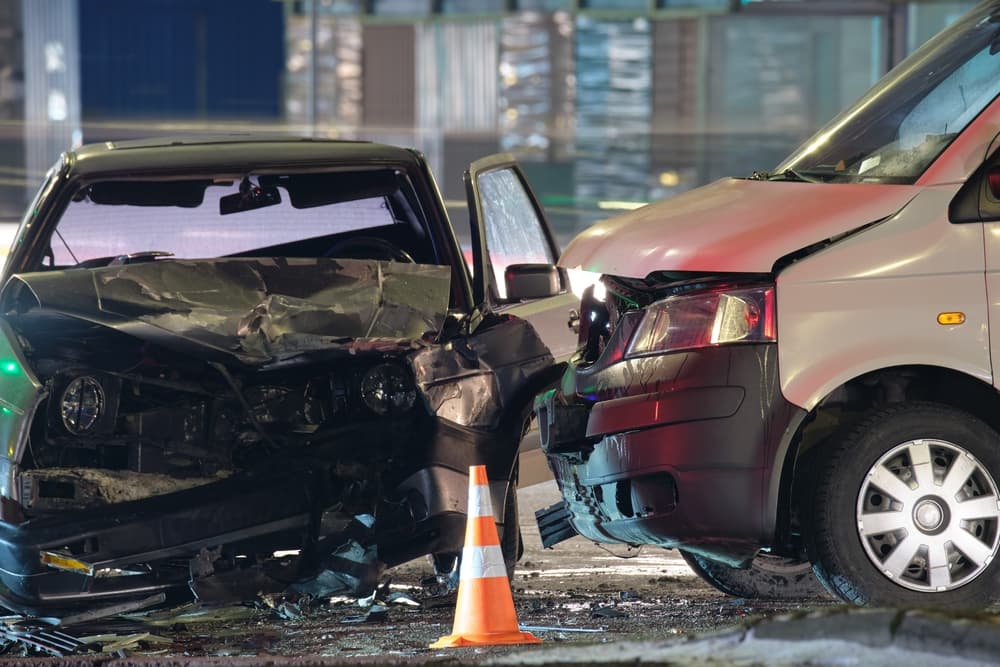 Cars crashed heavily in road accident after collision on city street at night.