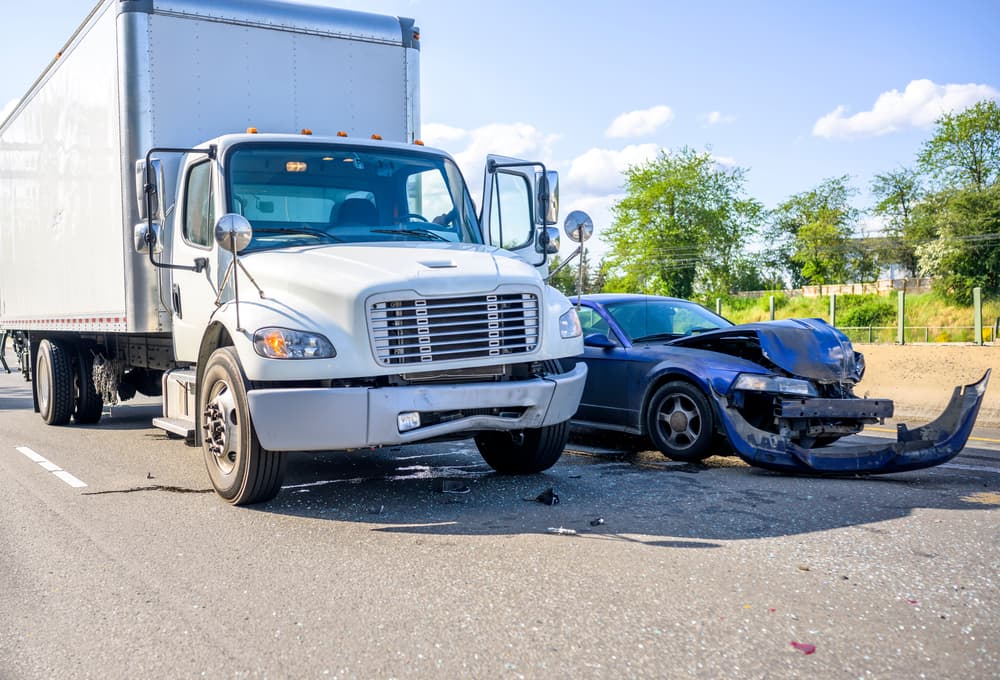 Collision of a semi truck with a passenger car on the highway road.