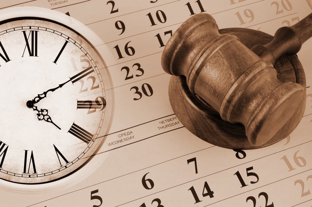 Wooden gavel and clock on paper calendar