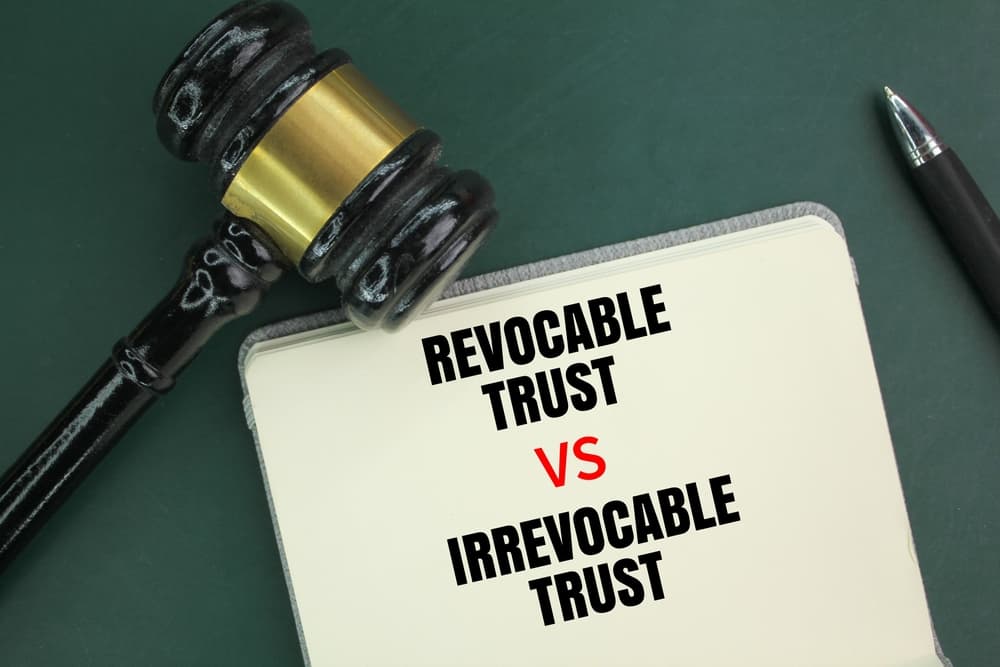 Judge's hammer, pen and book with the words Irrevocable Trust vs Revocable Trust