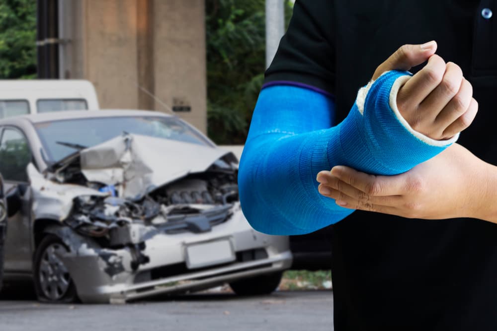 Close up man holding hand with blue bandage as arm injury